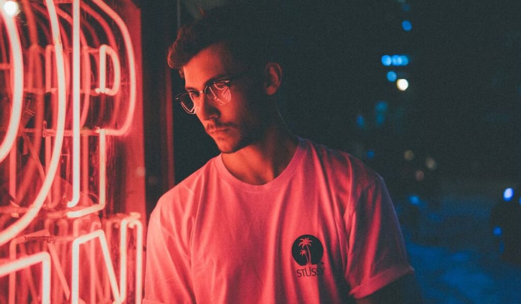entp man standing in front if pink neon
