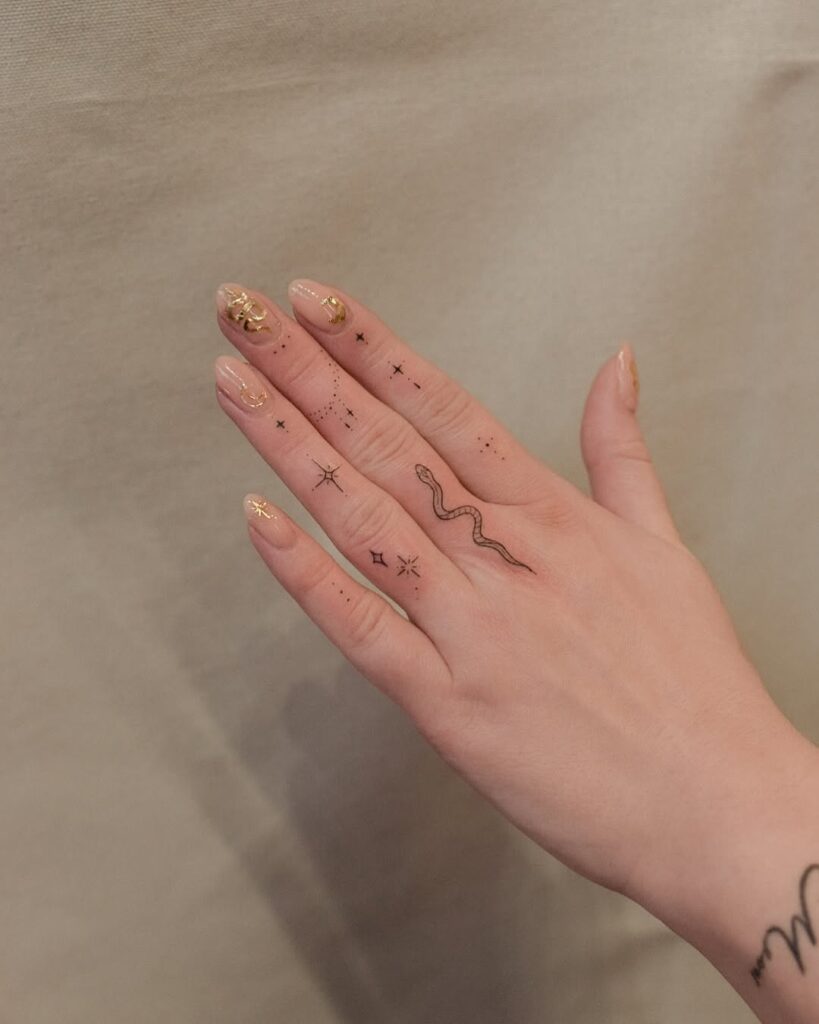 minimalist-snakes-and-stars-hand-tattoo