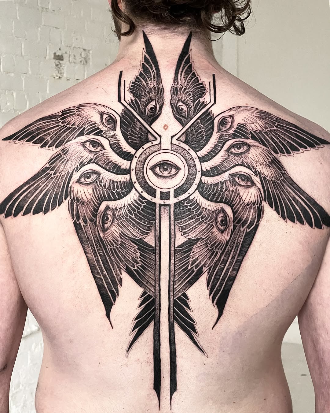 Intricate angel tattoo with multiple eyes and wings