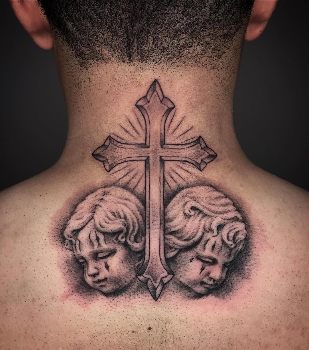 Angelic cherubs beneath a striking cross.