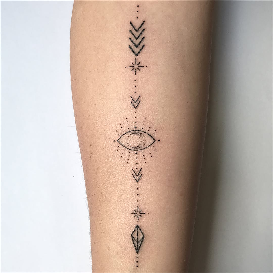 Geometric arrow tattoo with mystical eye design