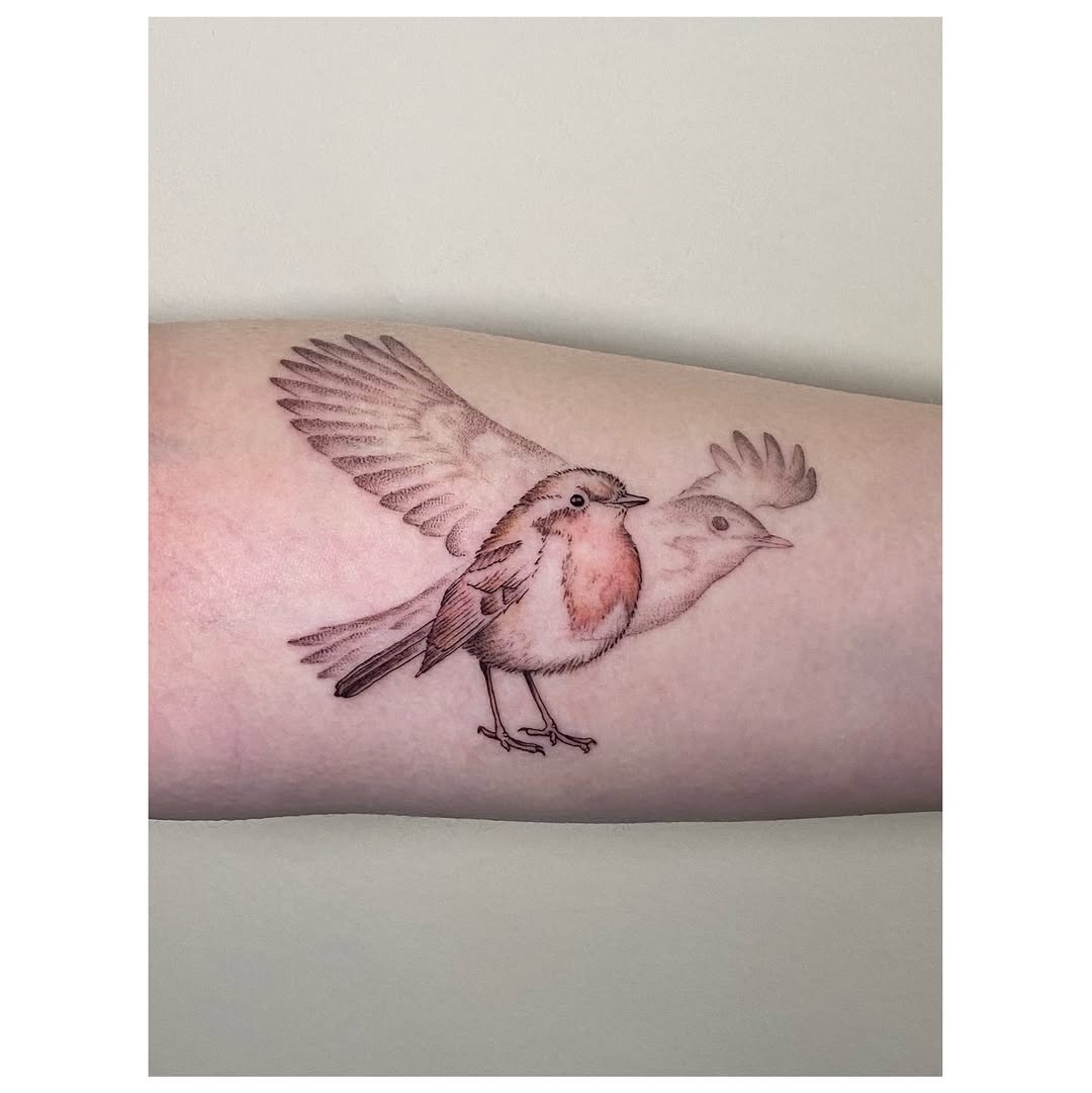 Whimsical bird tattoo in flight