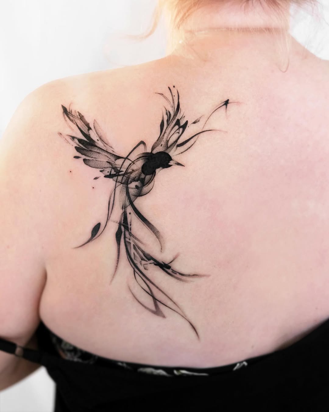 Elegant bird tattoo gracefully adorns the back