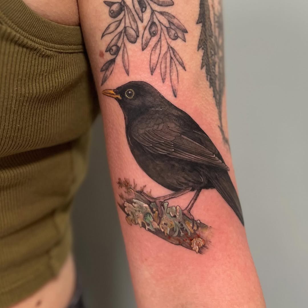 Beautiful blackbird tattoo on the forearm