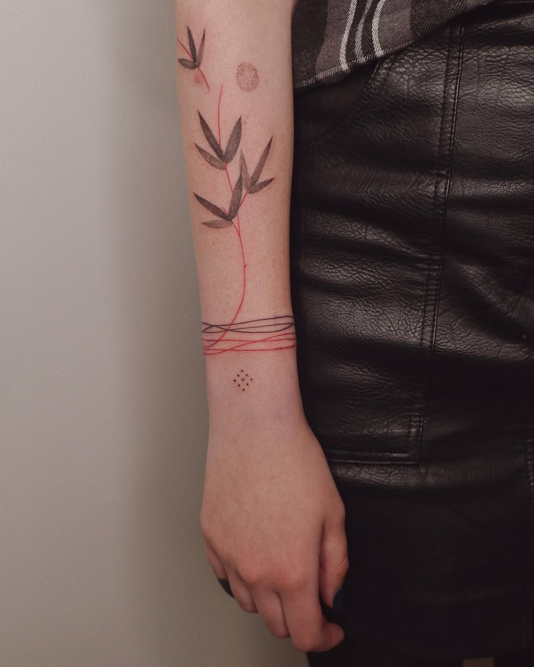 Elegant bracelet tattoo with bamboo and red accents