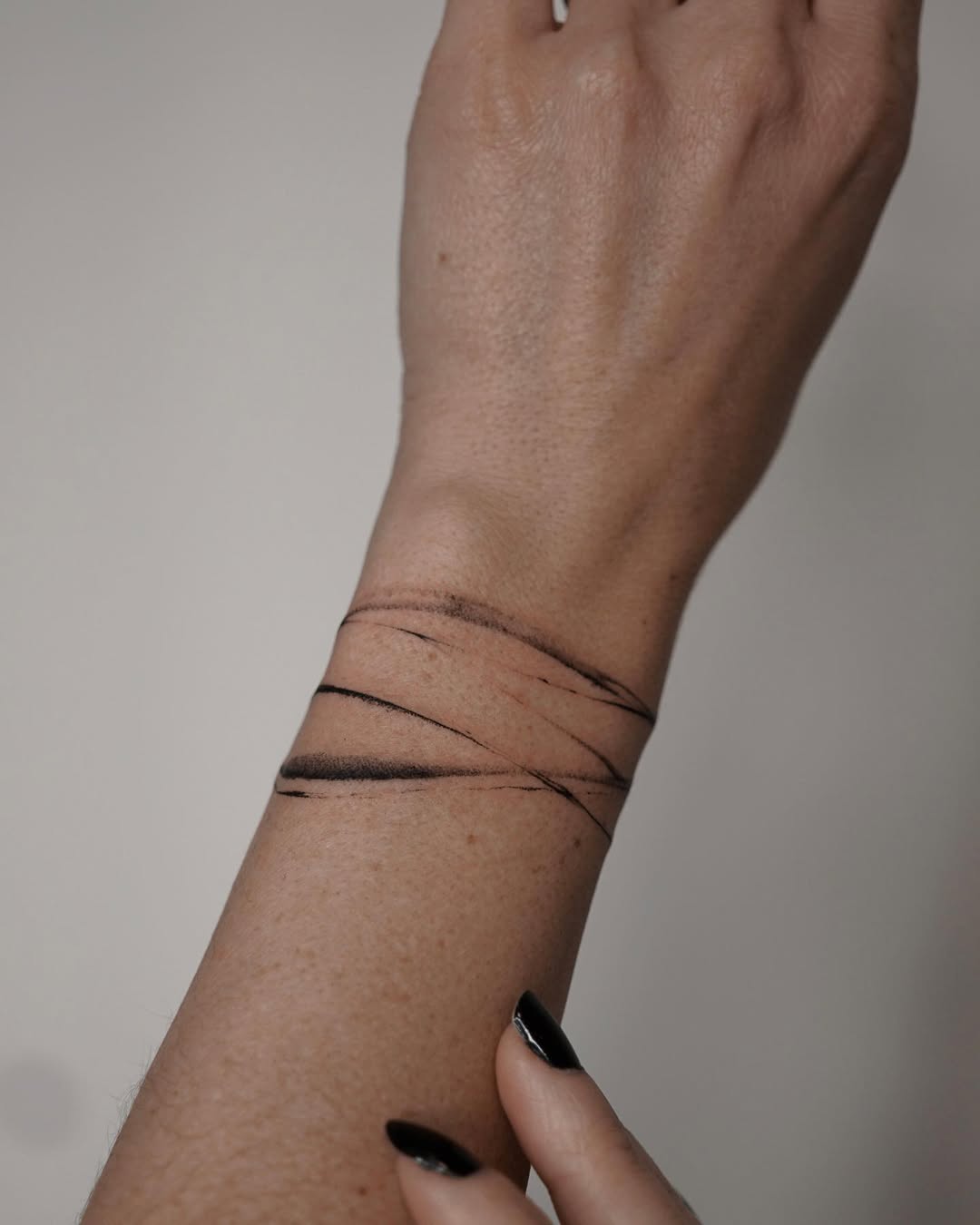 Unique black line art bracelet tattoo