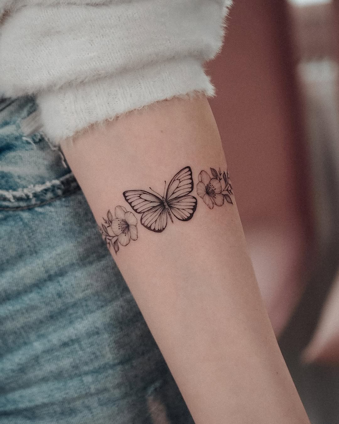 Elegant butterfly bracelet tattoo with floral accents