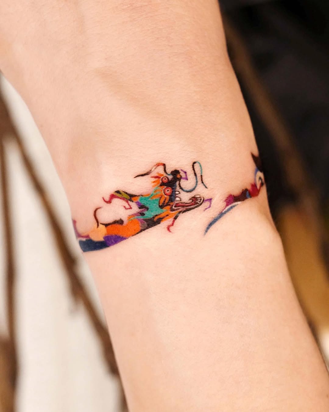 Vibrant dog tattoo wraps around the wrist.