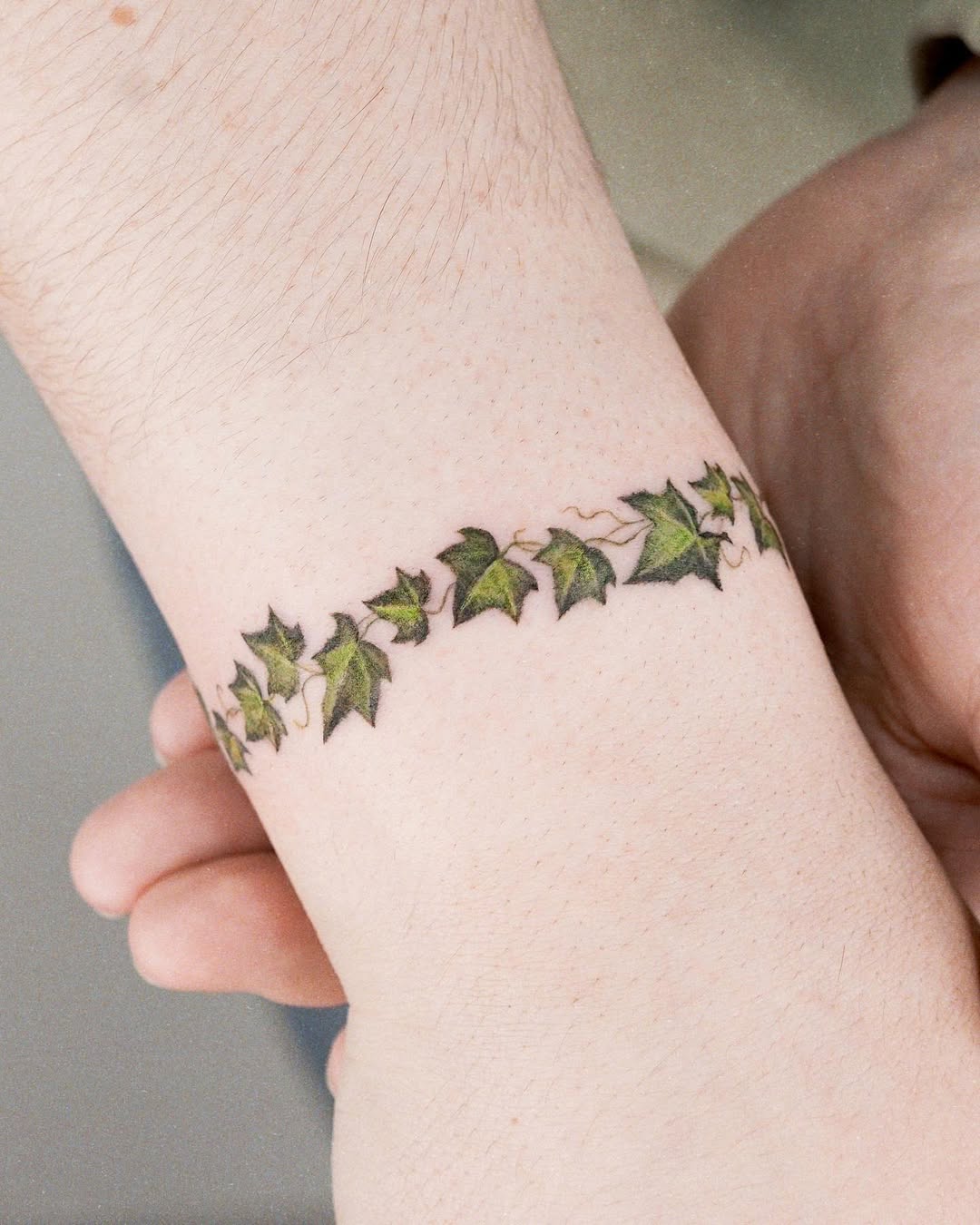 Delicate ivy bracelet tattoo on wrist