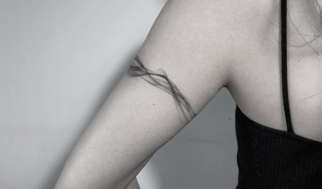 Elegant abstract bracelet tattoo on arm