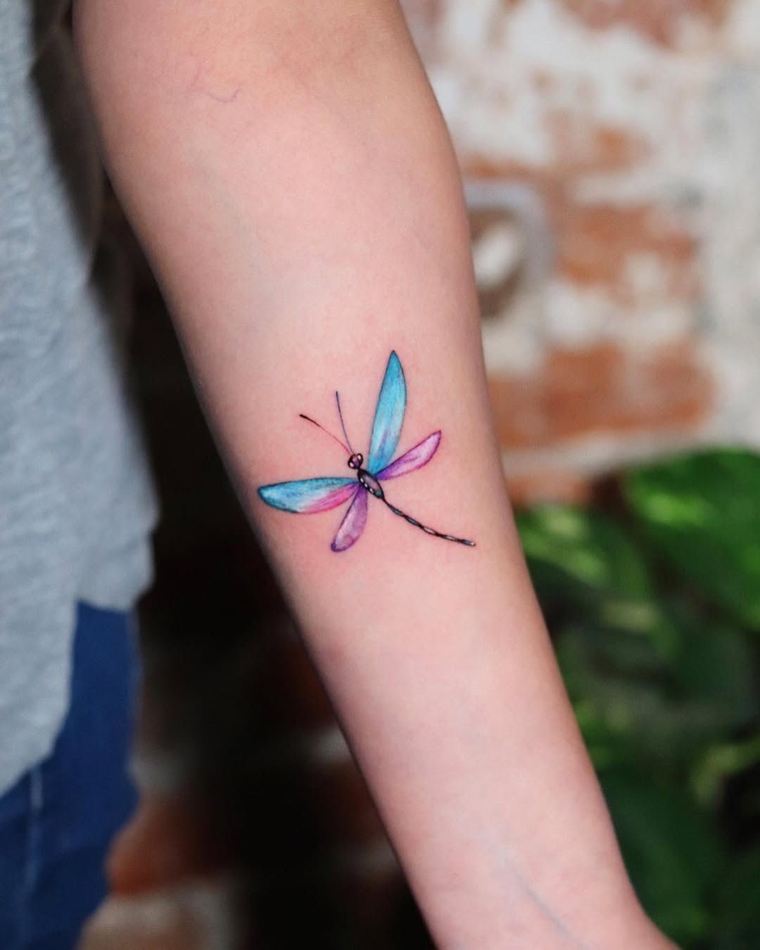 Vibrant dragonfly tattoo on forearm