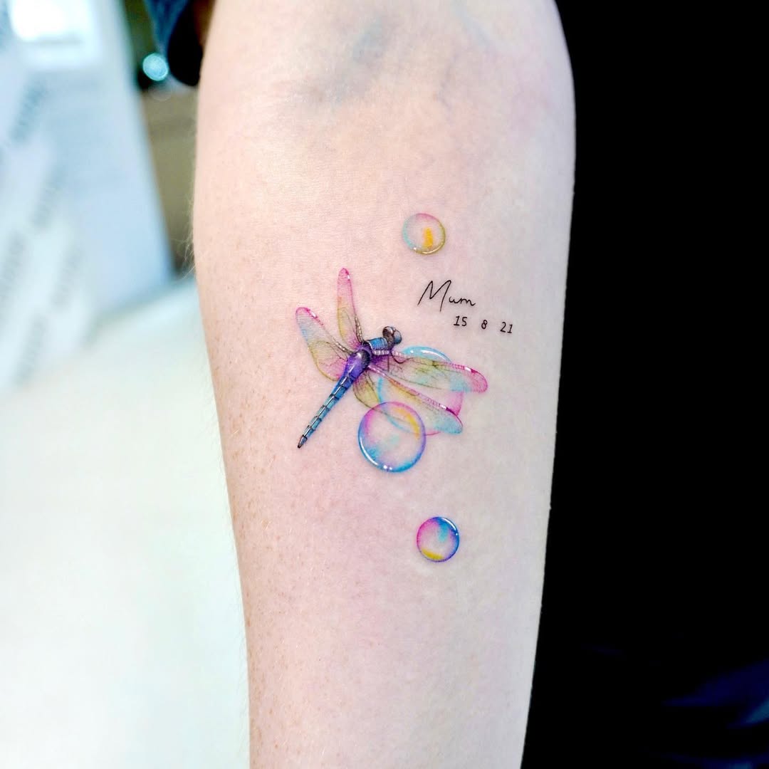 Vibrant dragonfly tattoo surrounded by playful bubbles