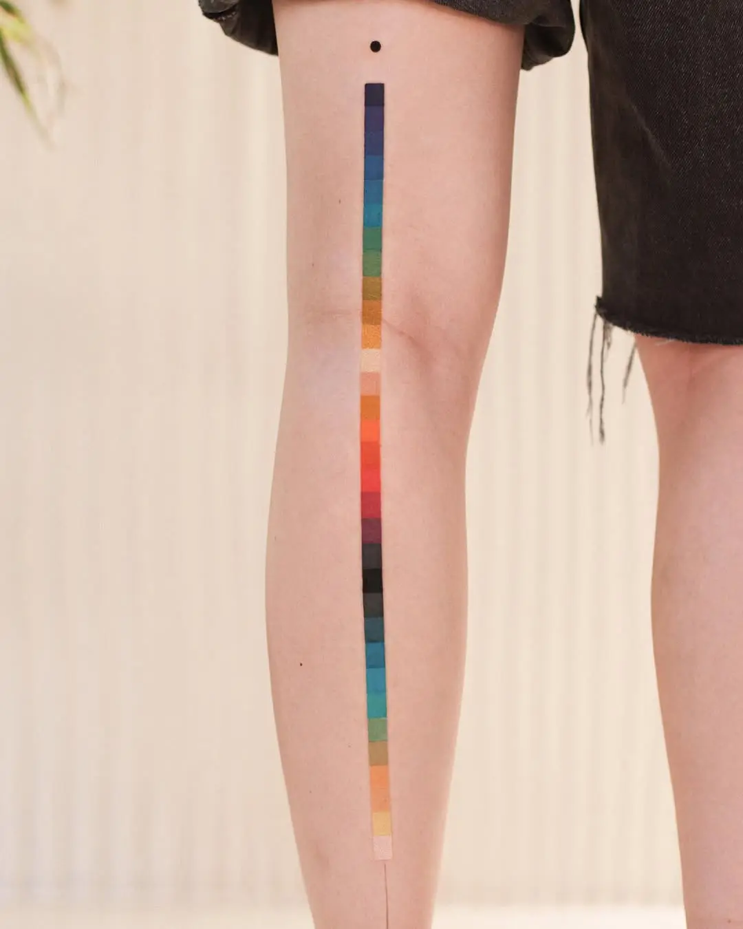 Minimalist Rainbow Tattoo on Stylish Leg