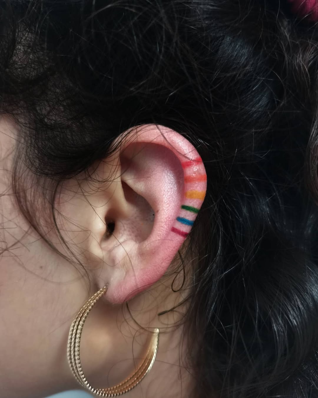 Vibrant Rainbow Tattoo on Ear Inspiration