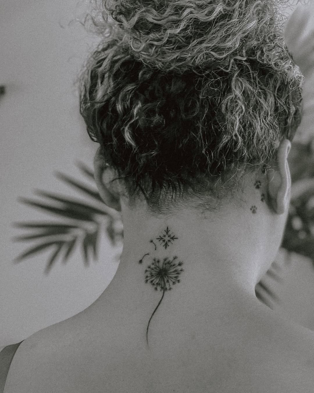 Delicate dandelion tattoo on the nape.