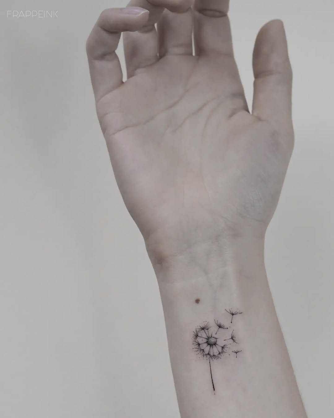 Elegant minimalist dandelion wrist tattoo design