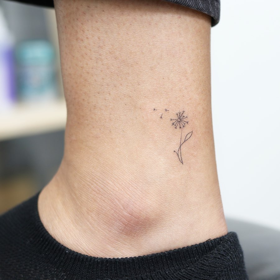 Charming minimalist dandelion tattoo on ankle