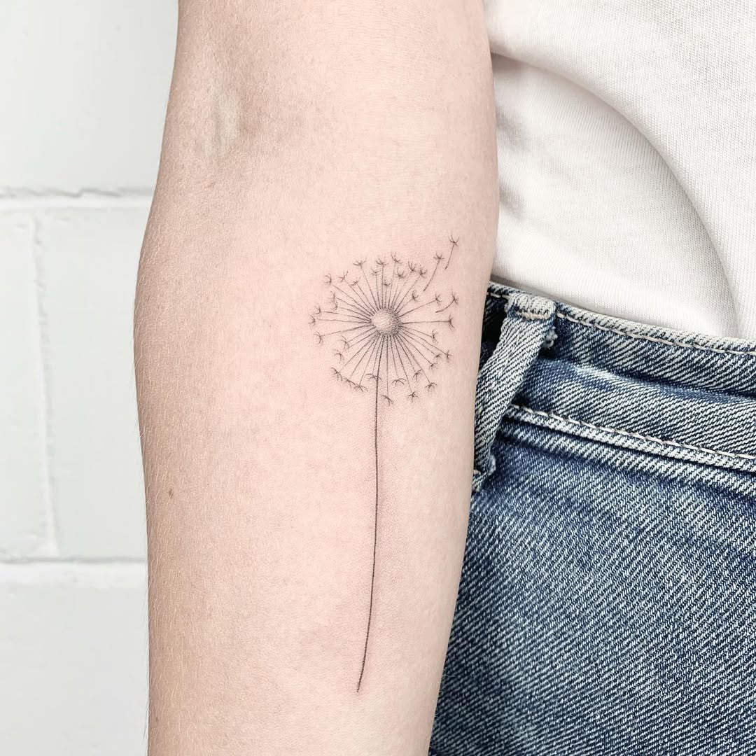 Elegant dandelion tattoo with delicate detail