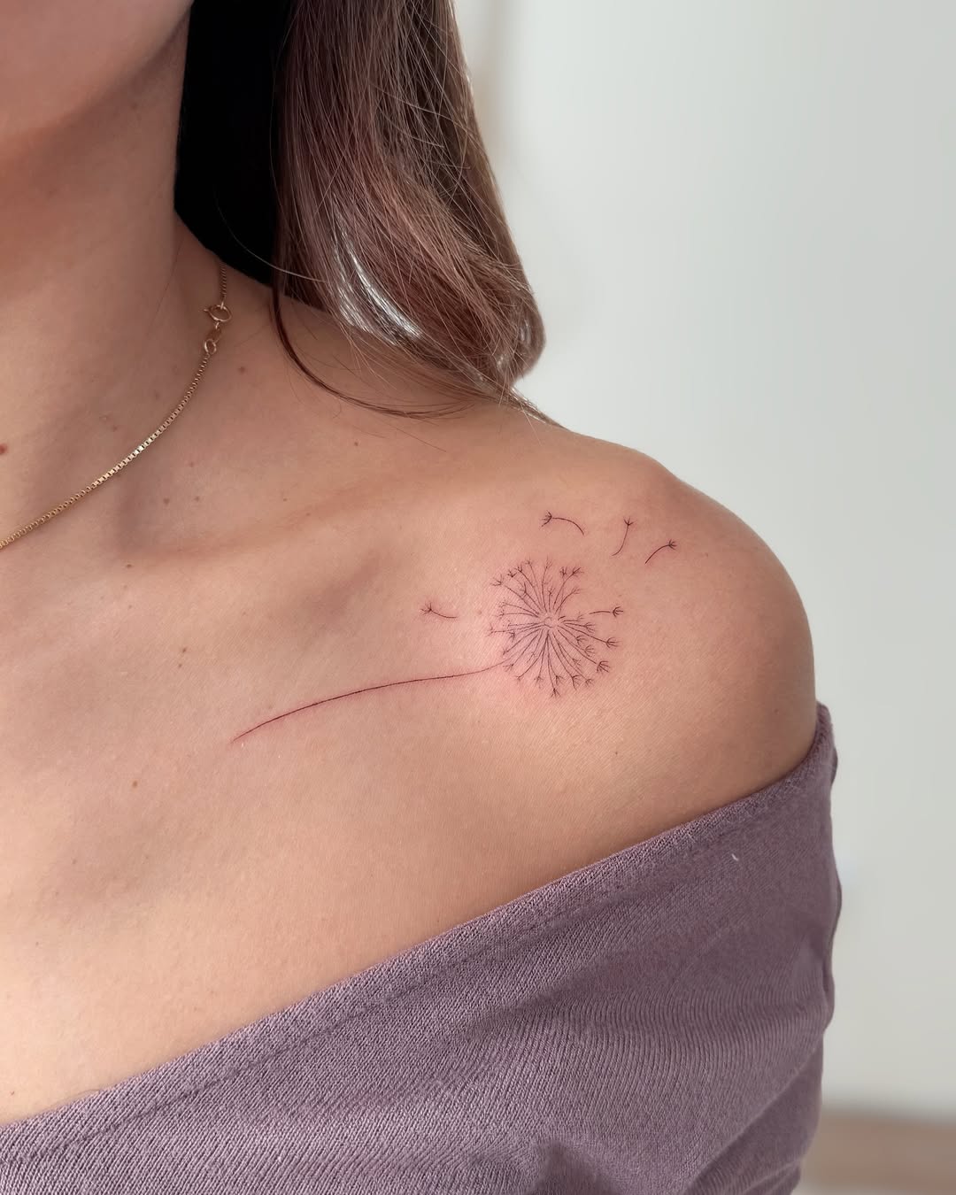 Delicate dandelion tattoo on the shoulder