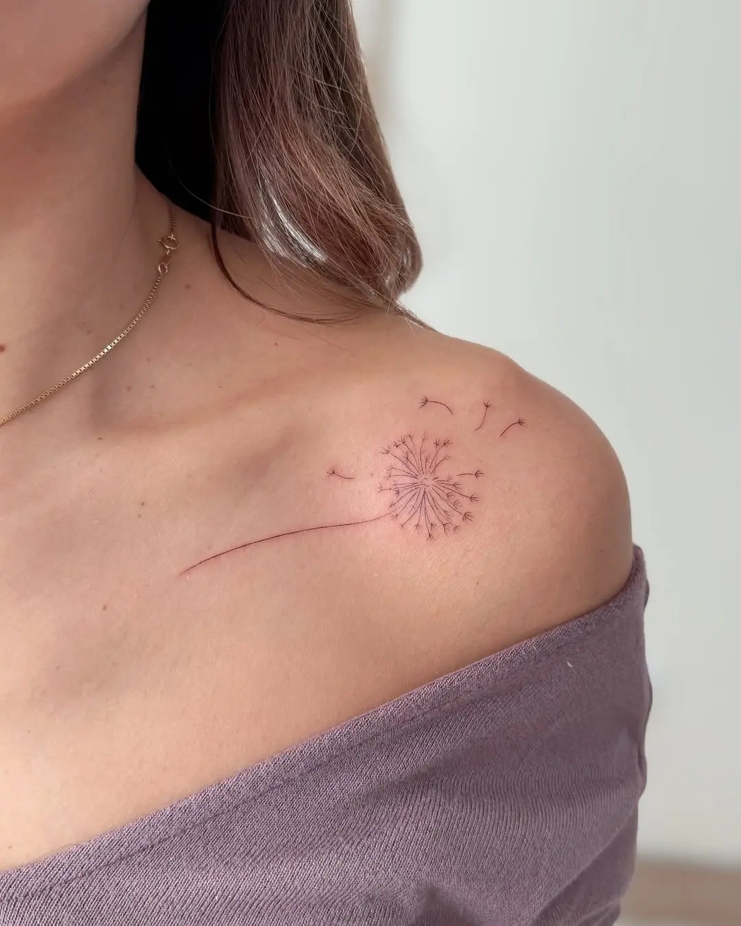 Delicate dandelion tattoo on the shoulder