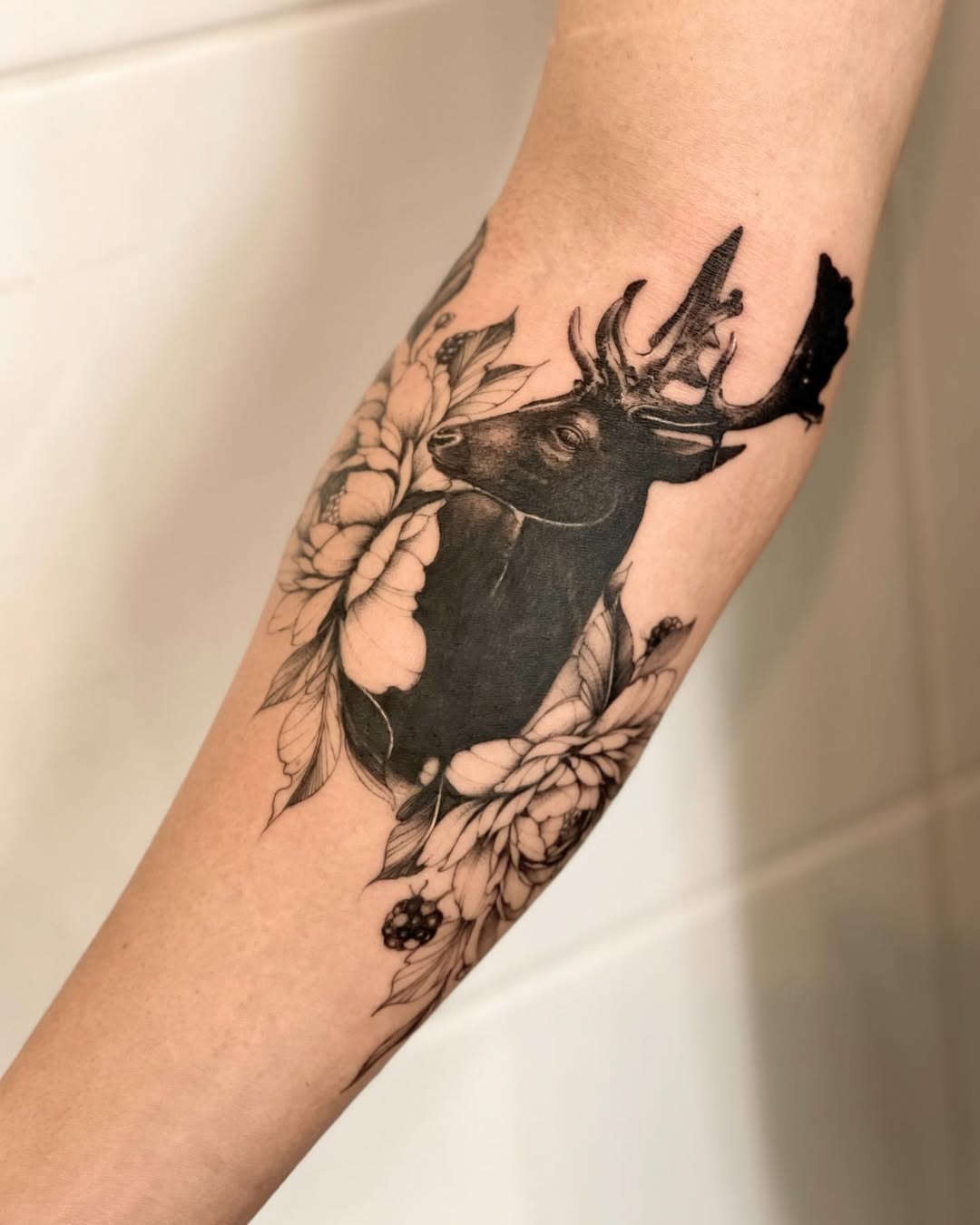 Elegant deer tattoo with floral elements