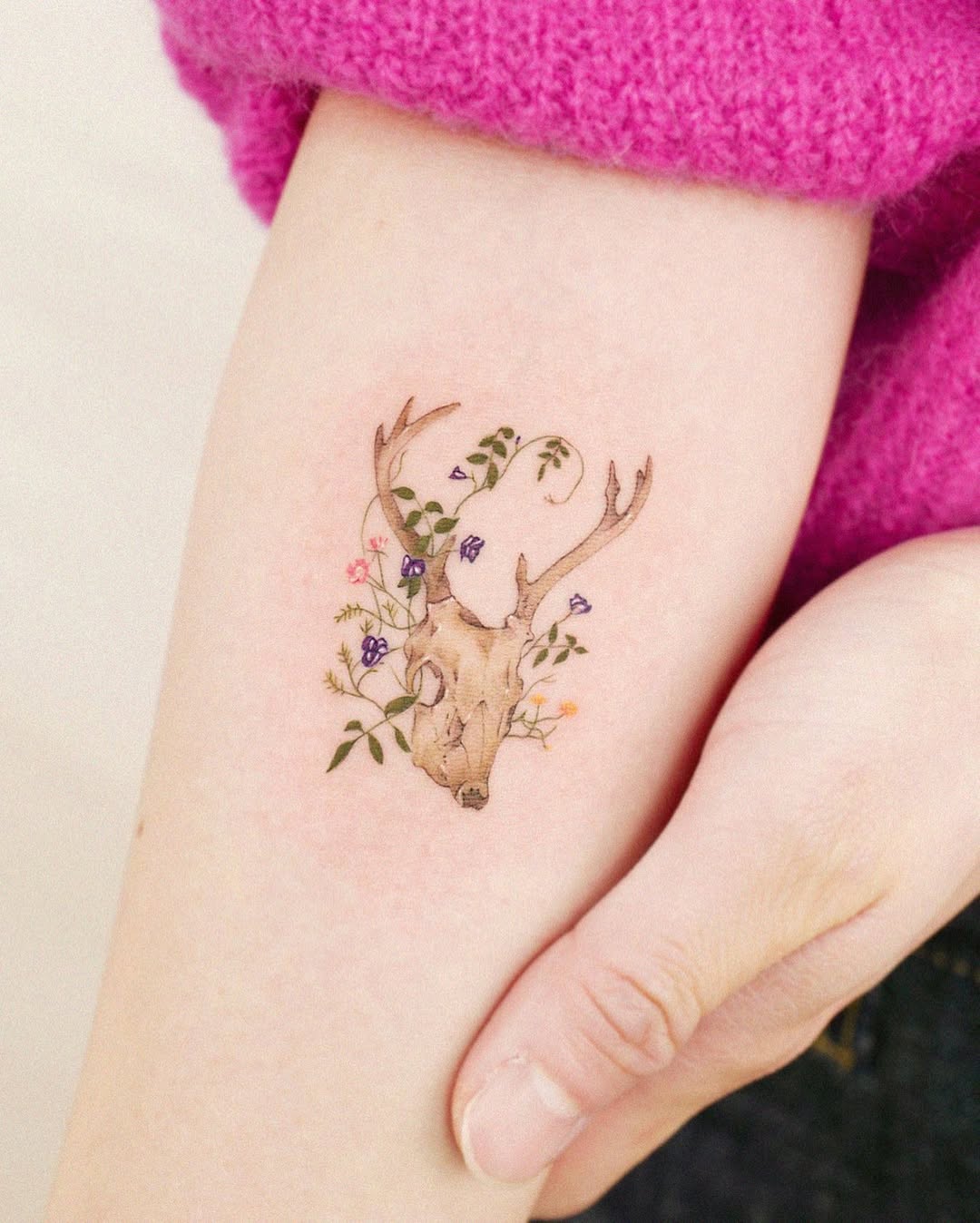 Elegant deer skull tattoo with floral accents