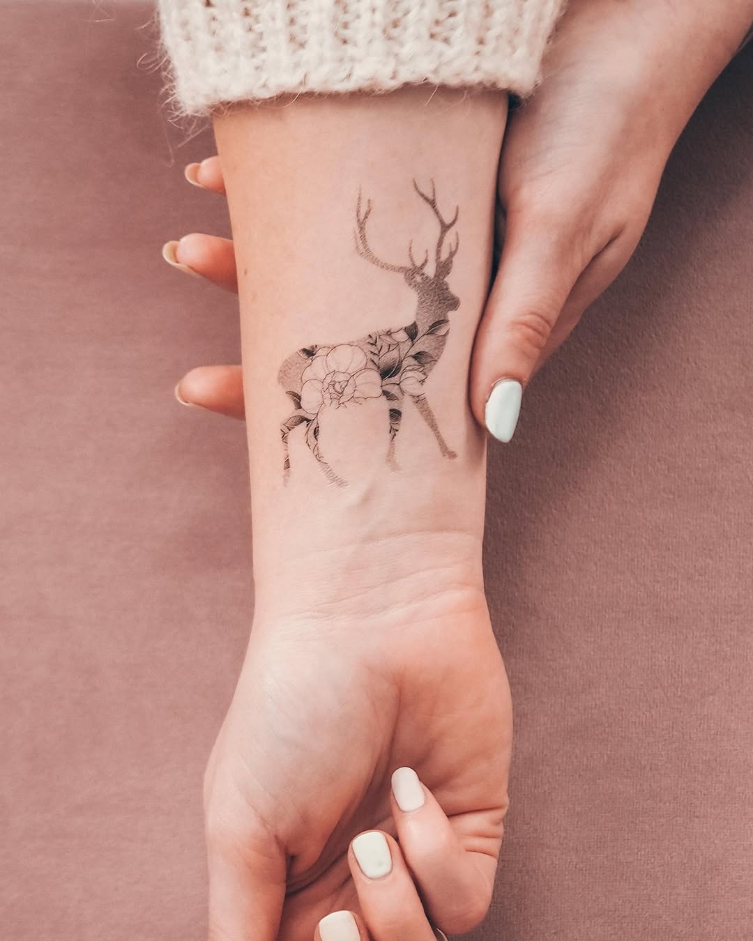 Elegant deer tattoo adorned with floral elements