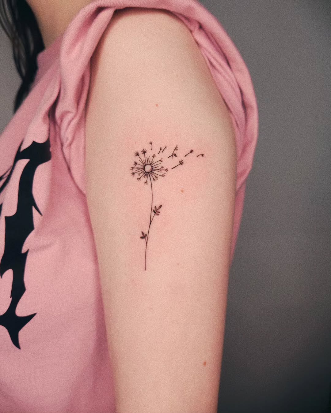 Delicate dandelion tattoo with flowing seeds