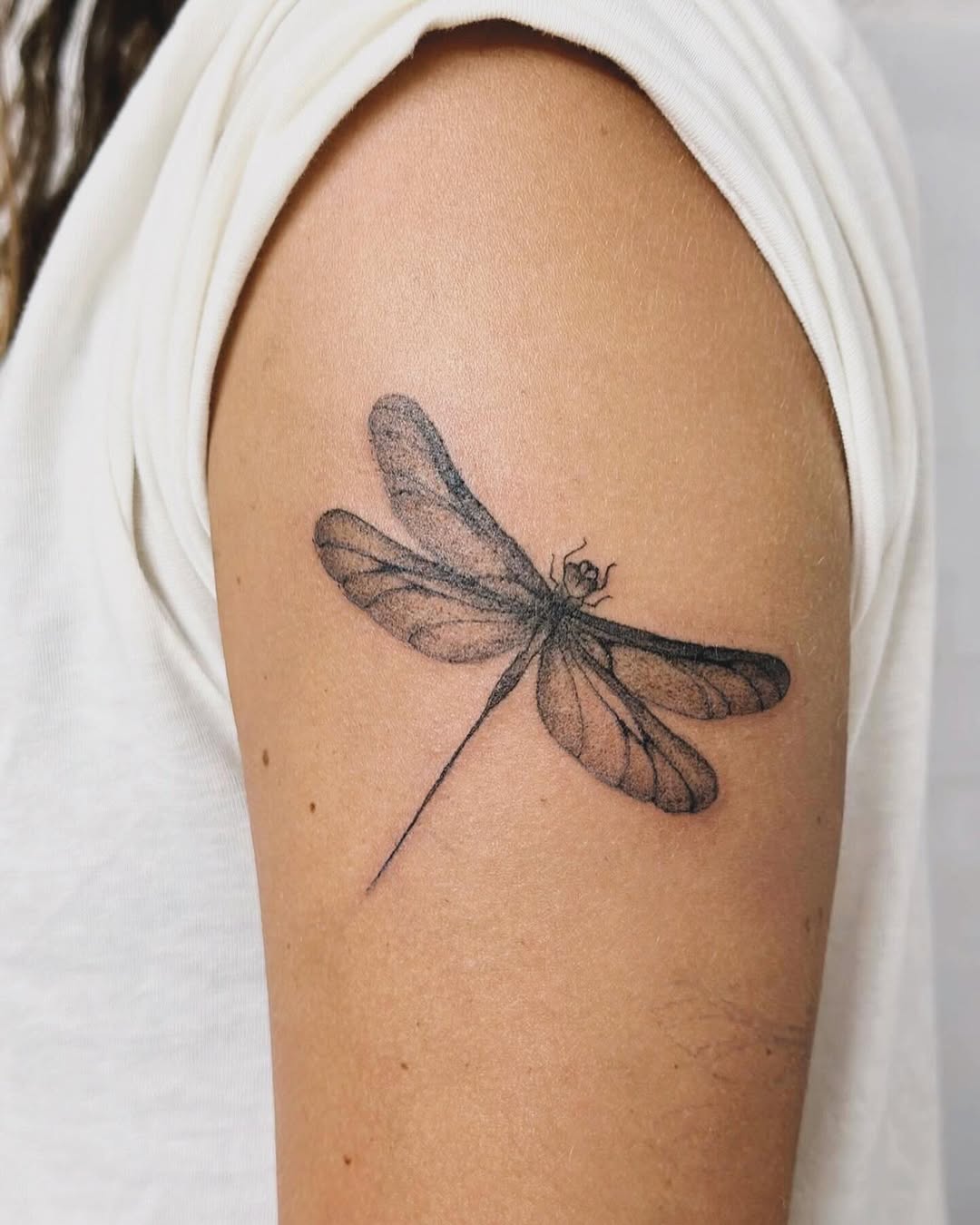 Elegant dragonfly tattoo on bare skin