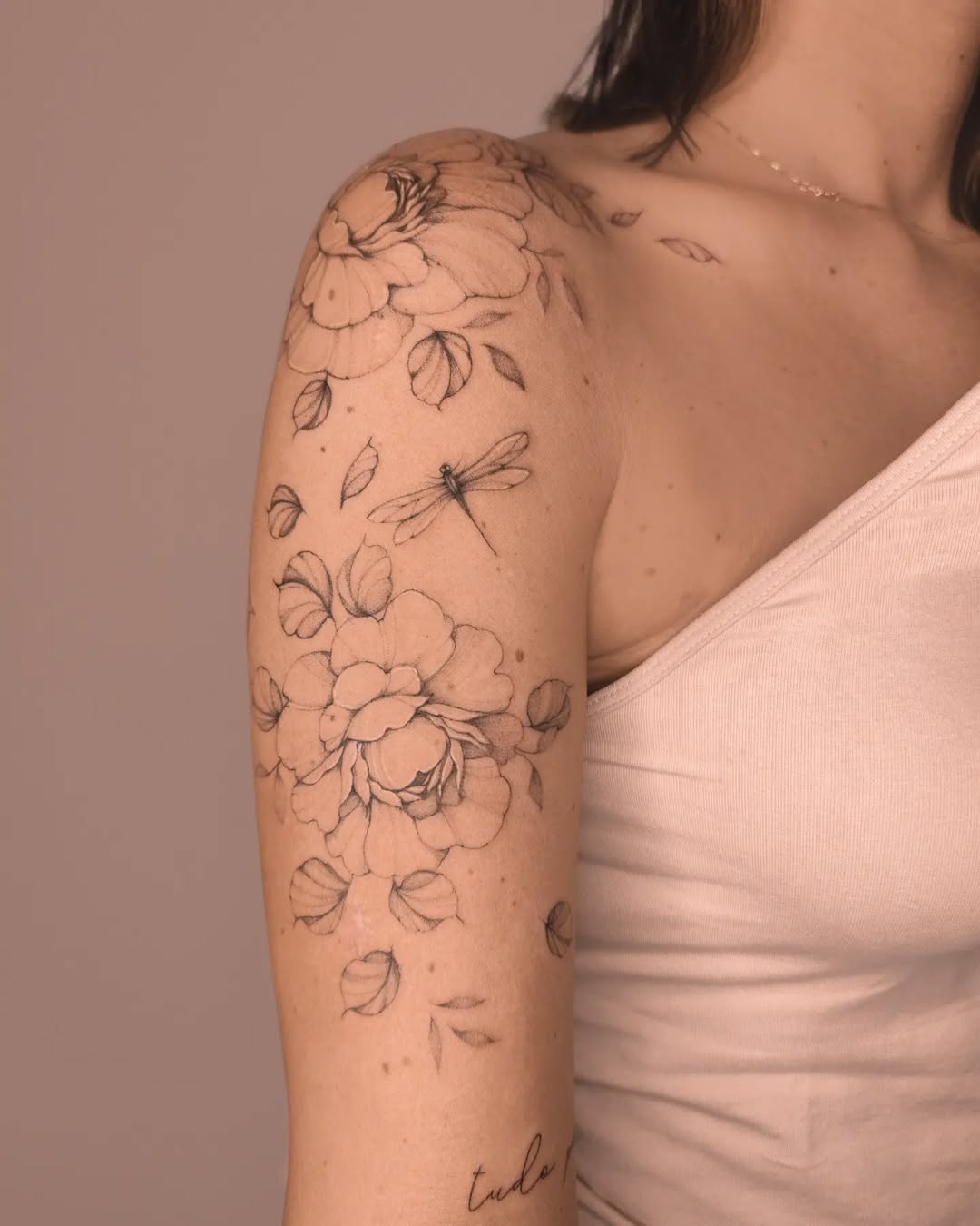 Elegant dragonfly tattoo among floral designs