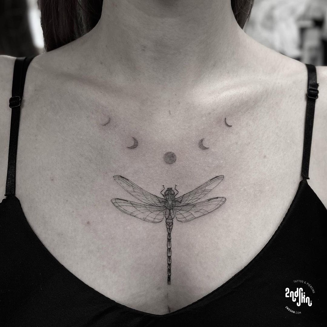 Elegant dragonfly tattoo with moons above