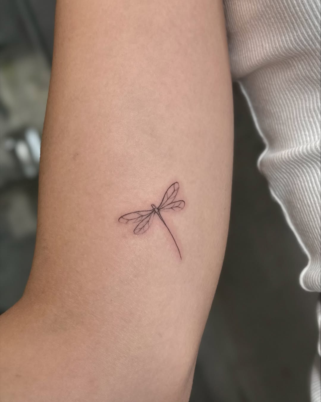 Elegant Fine Line Dragonfly Tattoo on Skin