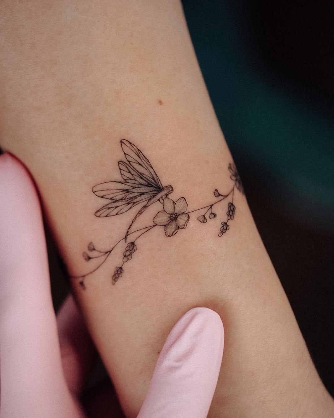 Delicate dragonfly tattoo with floral elements