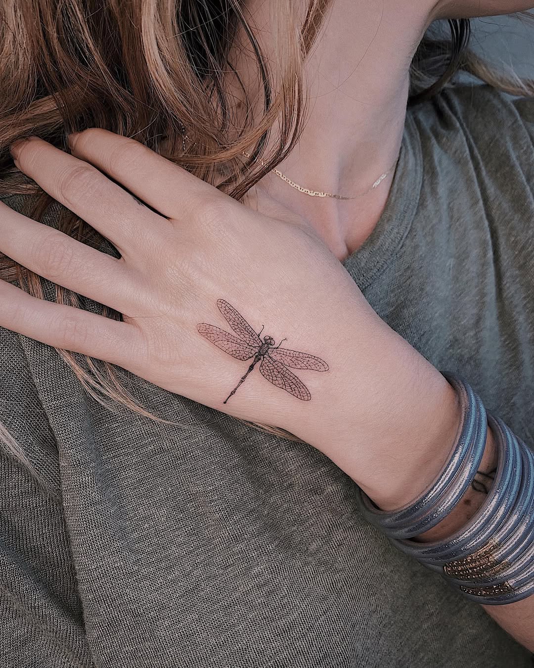 Elegant dragonfly tattoo on a hand