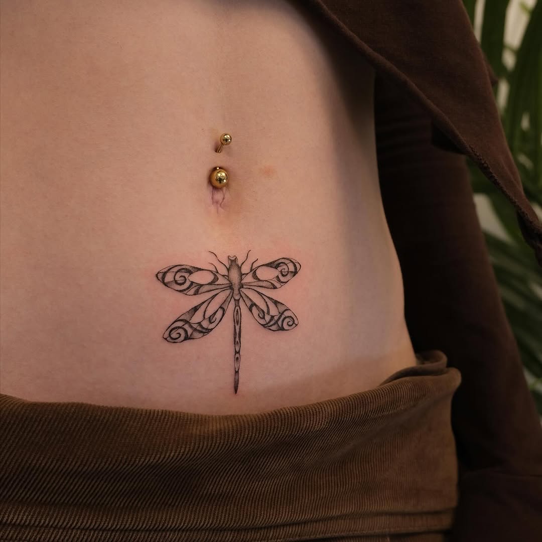 Elegant dragonfly tattoo on a smooth belly