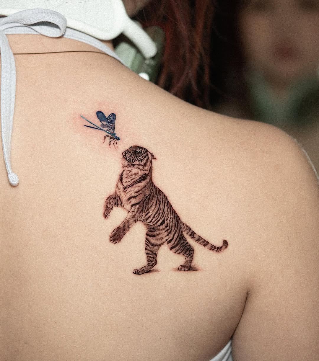 Dynamic tattoo of a tiger with dragonfly