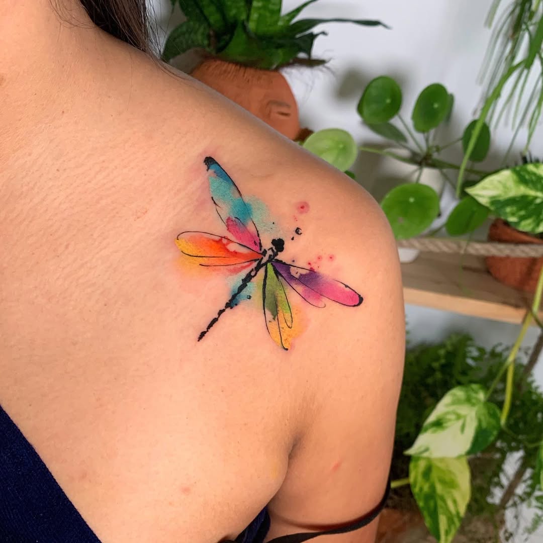 Vibrant watercolor dragonfly tattoo on shoulder