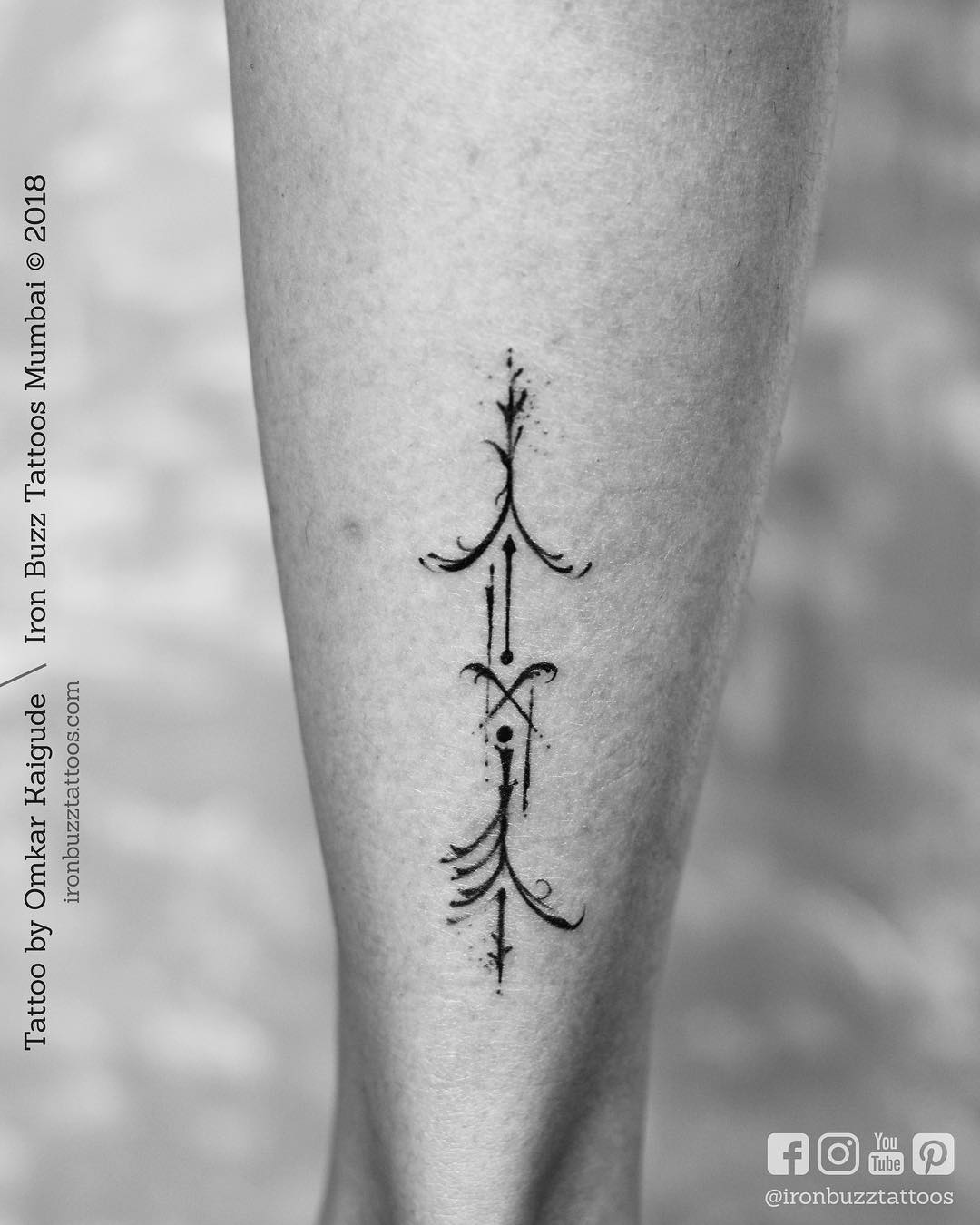 Sleek Arrow Tattoo with Intricate Flourishes