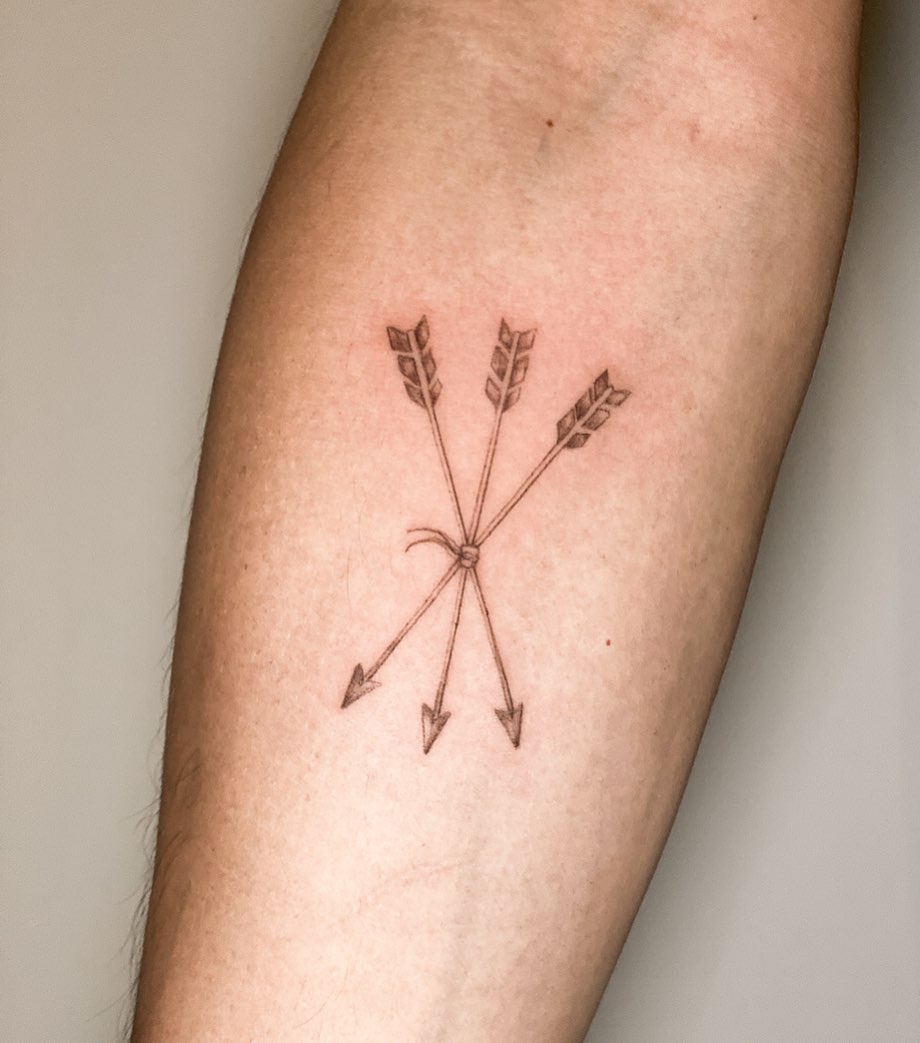 Elegant four-arrow tattoo on forearm