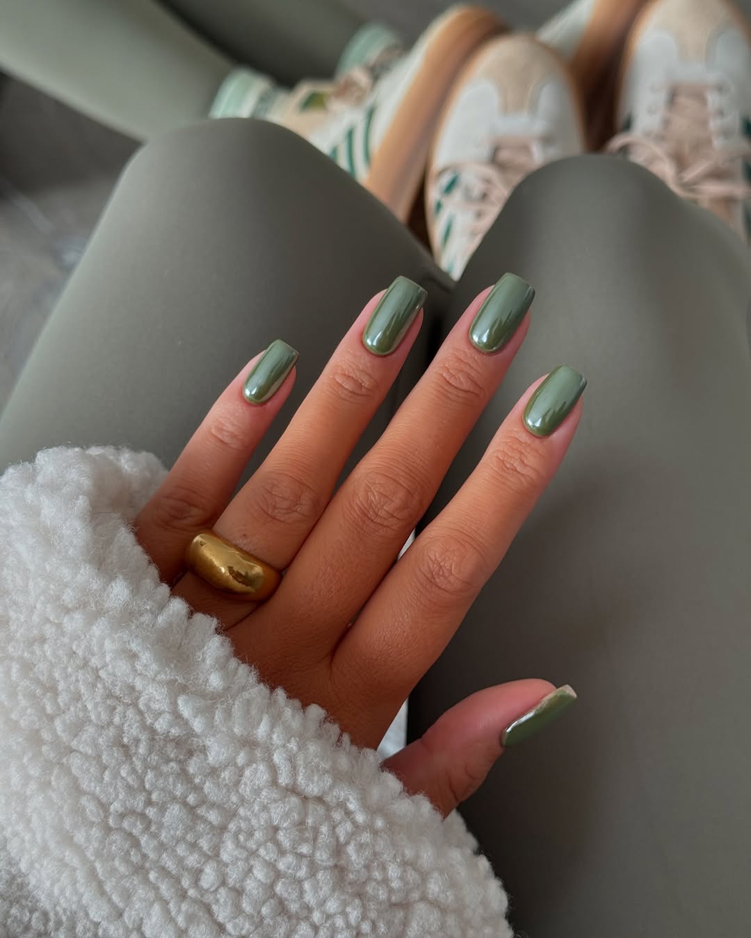 Chic green nails paired with cozy attire