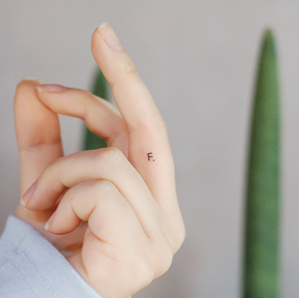 Chic Minimalist Initials Tattoo on Finger