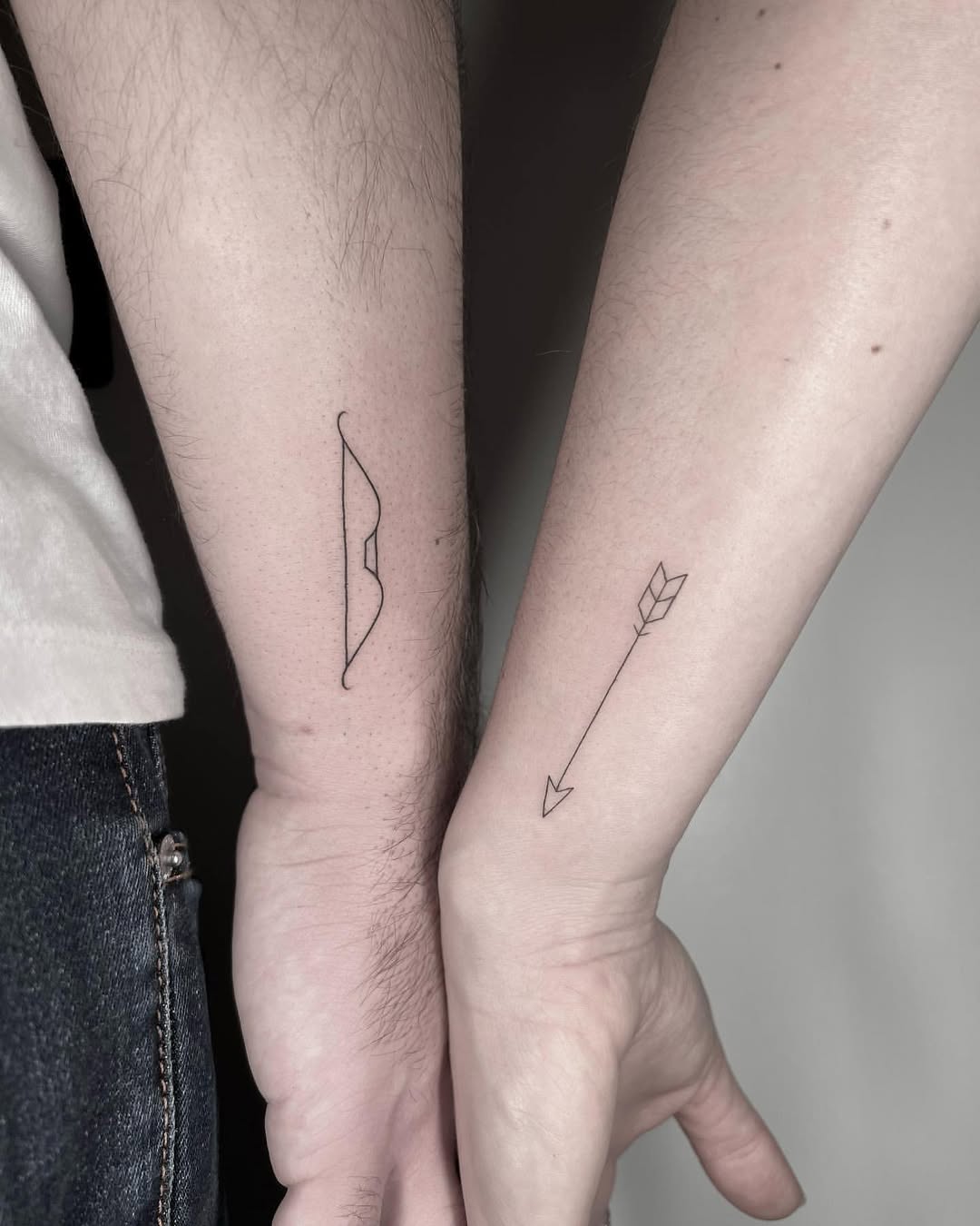 Minimalist tattoo of a bow and arrow