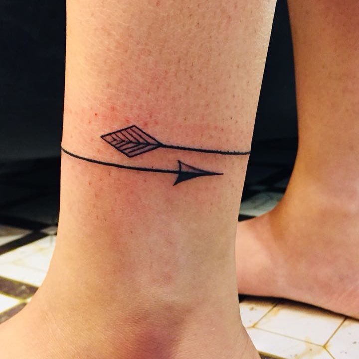 Elegant minimalist arrow tattoo on ankle