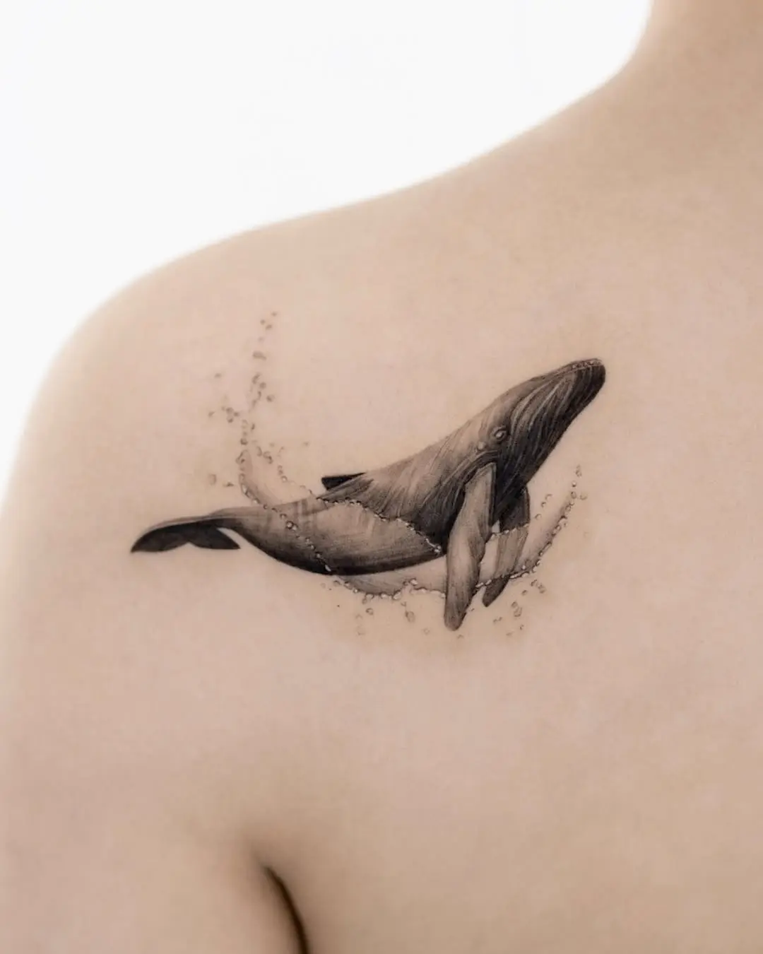 Elegant black and gray whale tattoo on shoulder