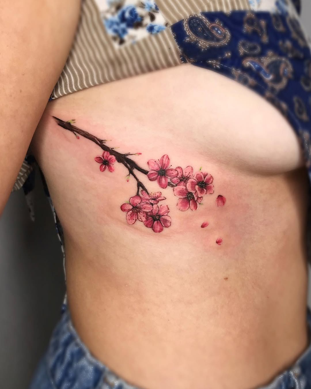 Delicate Rib Tattoo Featuring Pink Blossoms