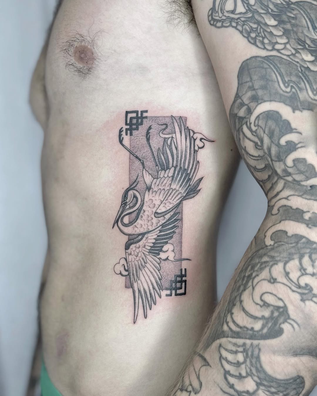 Elegant Crane Rib Tattoo in Black Ink