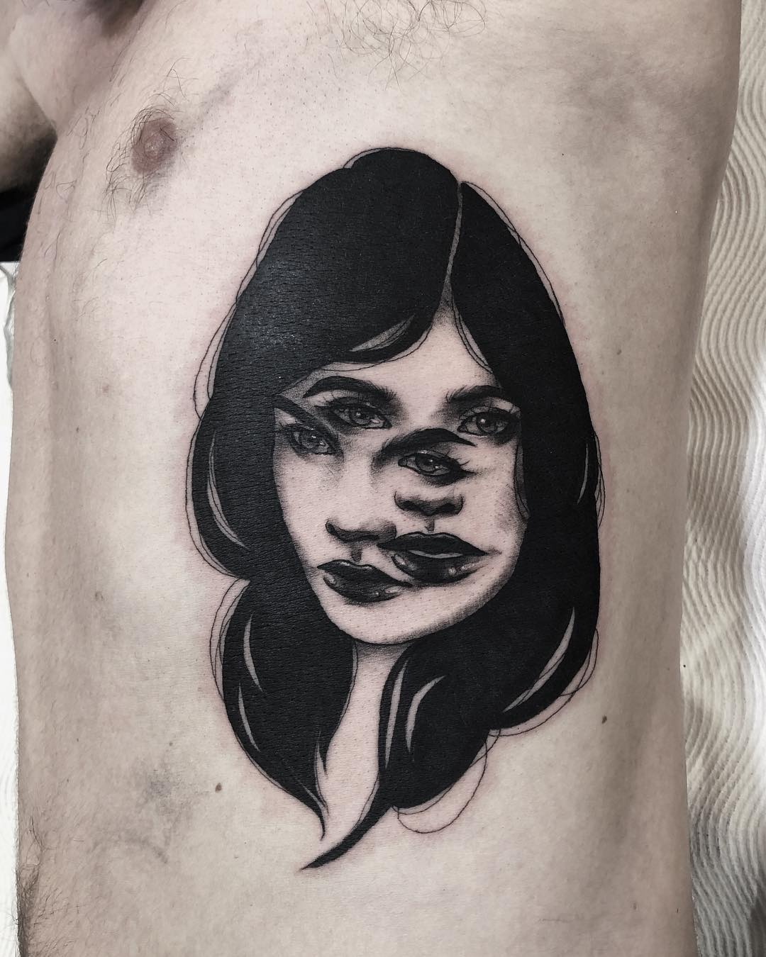 Artistic Rib Tattoo of Mysterious Faces