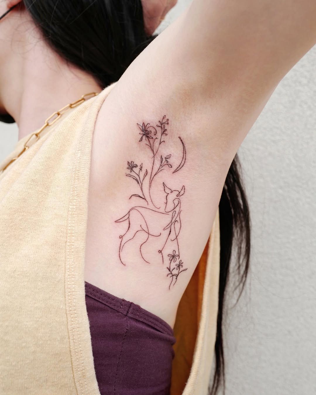 Delicate deer tattoo with floral elements