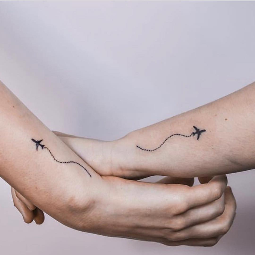 Meaningful sister tattoos featuring airplane design