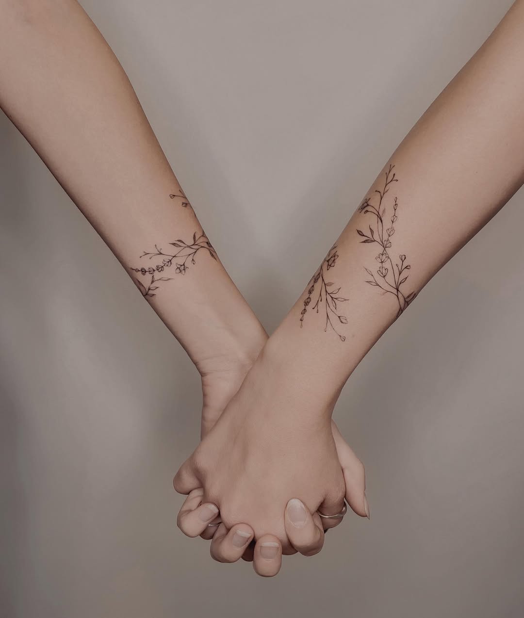 Delicate floral sister tattoos on wrists